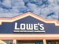 Close-up logo of LoweÃ¢â¬â¢s hardware store entrance under cloud blue sky